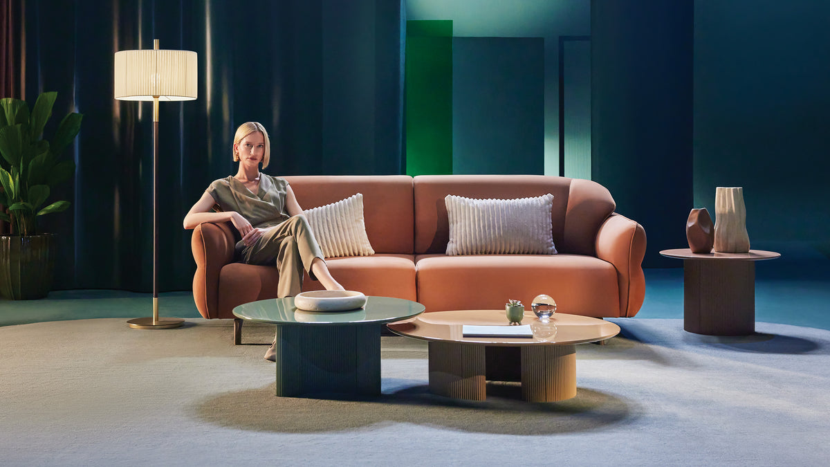Woonkamer met oranje bank en ronde salontafels van Enza Home
