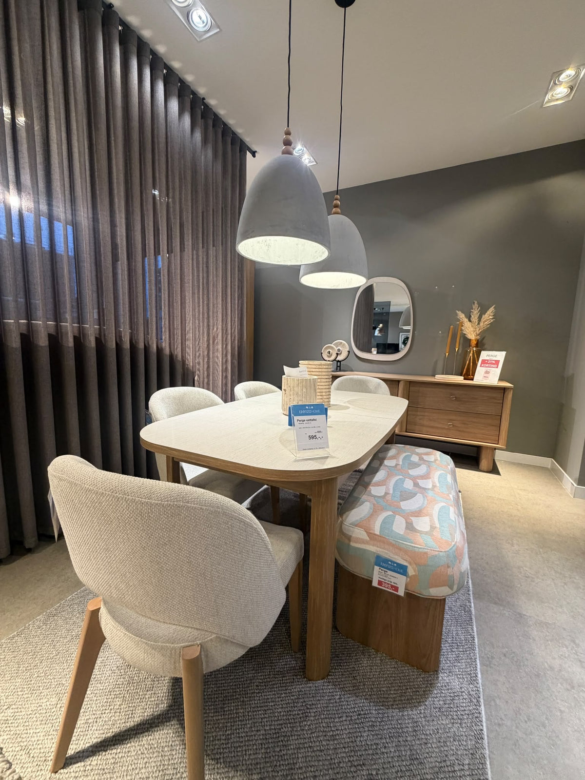 Ingerichte eethoek met eettafel, stoelen en bank in de showroom van Enza Home Rotterdam